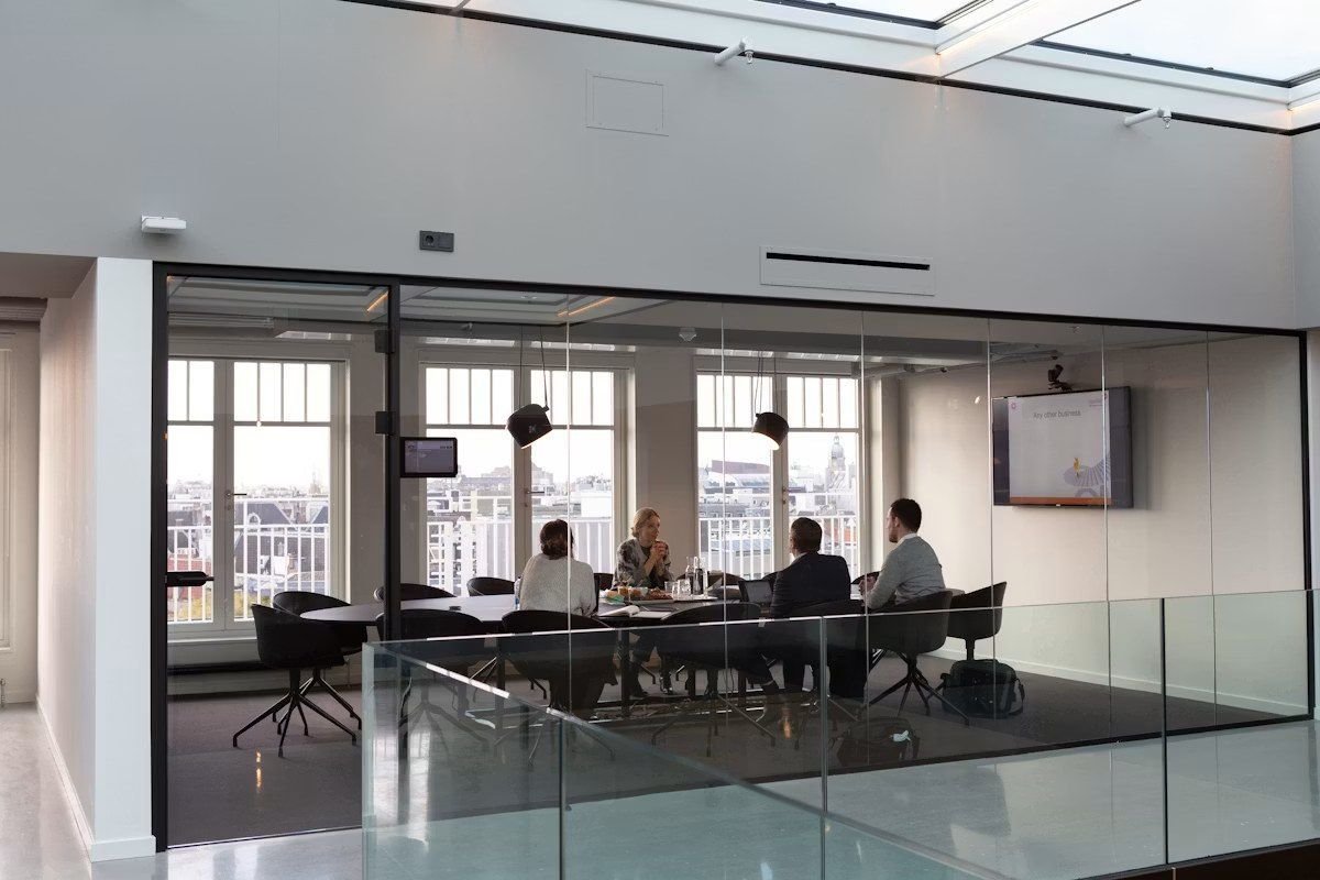 Reunión de equipo en una sala de cristal con vistas a la ciudad
